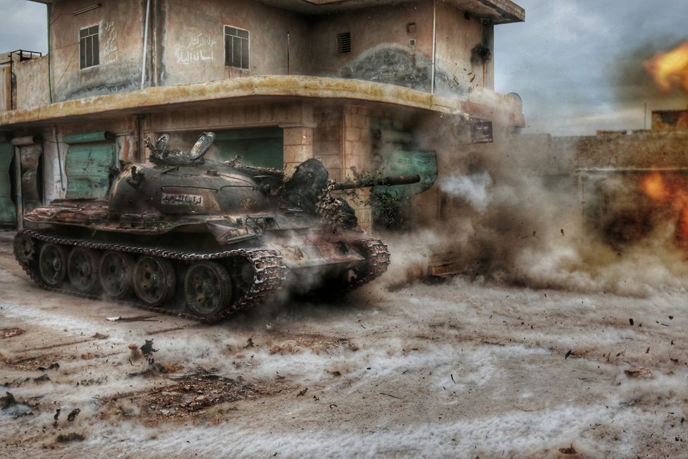 Un tanque dispara frente a un edificio en Aleppo generando una nube de humo y polvo
