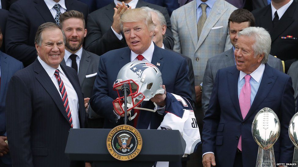 President Trump holding an American football helmet