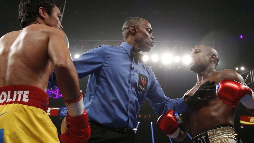 The referee splits US boxer Floyd Mayweather Jr., (R) and Manny Pacquiao