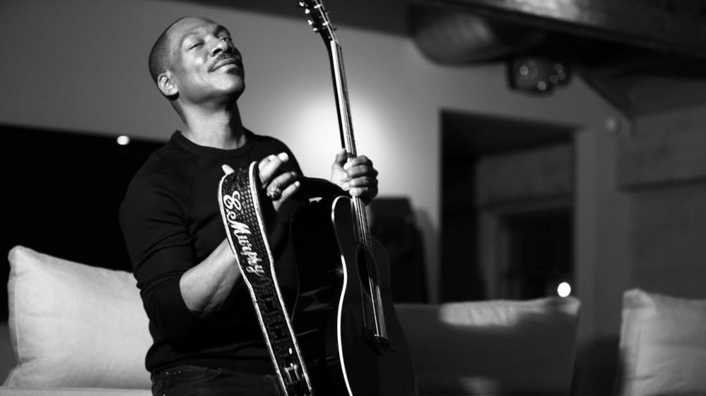 Eddie Murphy poses with a guitar