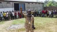 Emotion Brice Namsio of Bangui's anti-balaka, speaks to fellow militia men.