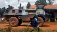 French Sangaris troops patrol in an armoured personnel carrier (APC) as a schoolboy passes by, in Bangui, the Central African capital, on 13 July 2014.