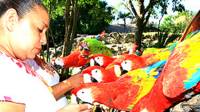 Visitante junto a guacamayas en el Parque Xcaret