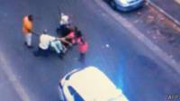 Video mostra policial agredindo com cassetete mulher deitada no chão (foto: AFP)