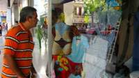 Un transeúnte mira la vitrina de una tienda estatal