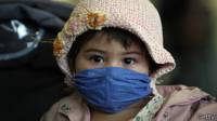 Niña con tapaboca durante brote de gripe aviar