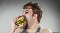 Hombre comiendo hamburguesa