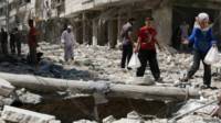 Niños evacúan un lugar atacado con bomba, en Siria