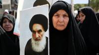 Mujer con imagen de Alí al Sistani