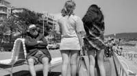 Hombre mirando con descontento a chicas en minifalda.
