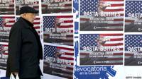 Un hombre en Argentina pasa frente a una pancarta de protesta contra los fondos buitre