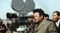 Kim Jong-il mirándo por una cámara