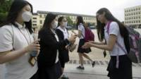 韓國一家高中門前學生給同學噴灑手腕消毒藥水（9/6/2015）