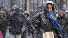 Người đi bộ chống trả với gió mạnh và tuyết rơi trên đường phố Manhattan, New York