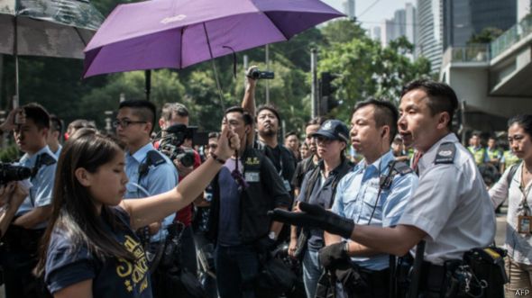香港金钟道上一名警员与举着雨伞的“占领中环”女示威者理论（14/10/2014）