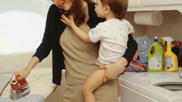 Mujer con niño planchando