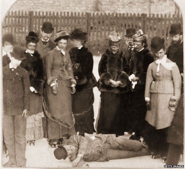 Un grupo de entusiastas en 1876 rodeando a un joven que se cayó.