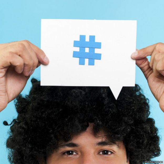 Una persona con un papel con hashtag sobre la cabeza