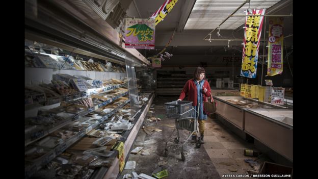 Esta imagen fue tomada por Carlos Ayesta y Guillaume Bression. Muestra a una extrabajadora de un supermercado, ahora abandonado, volviendo a ver los restos que quedaron tras la catástrofe de Fukushima, Japón.