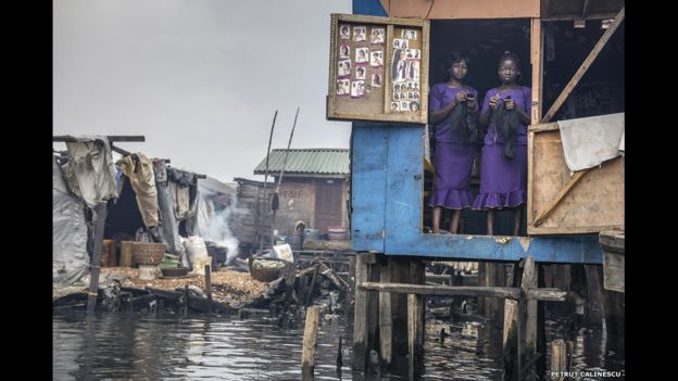 Esta foto de Petrut Calinescu muestra a dos mujeres que dirigen un salón de belleza en su choza en Makoko, un barrio de chabolas construidas en una laguna en el borde de Lagos, Nigeria.