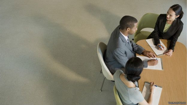Tres personas en una mesa de trabajo