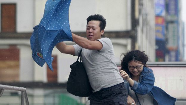 台北市民在强风中行走。