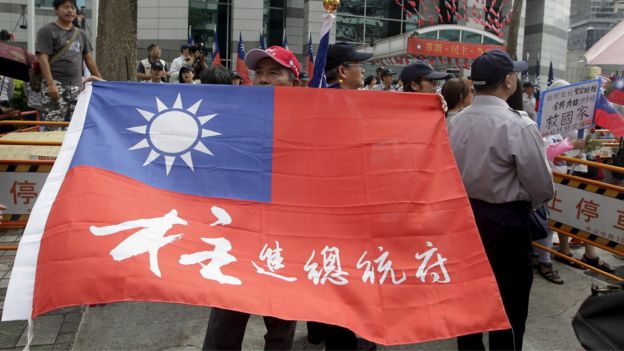 洪秀柱的一名支持者在台北國民黨中央黨部前舉起寫上「柱進總統府」字樣的中華民國國旗（7/10/2015）