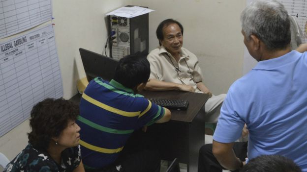 姓李凶徒（左二）和妻子接受菲律宾警察问话