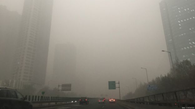 在雾霾中无法见到北京高楼的全貌。