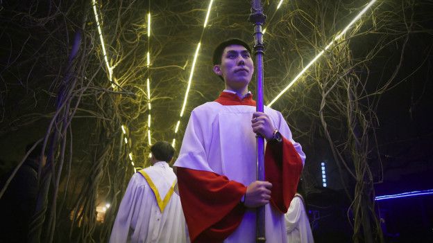 Крестоносец готовится возглавить процессию во время мессы в католической церкви в Пекине