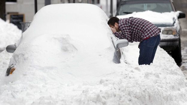Un hombre y un carro cubierto de nieve