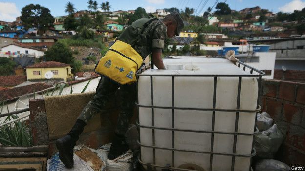 Soldado inspeccionando un tanque de agua en busca de larvas del mosquito trasmisor de zika