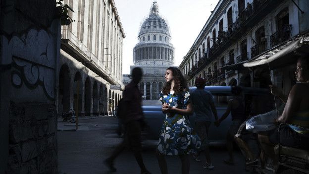 Una mujer posa con un vestido estampado con el Capitolio de La Habana de fondo