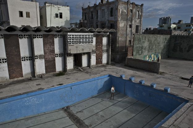 Una mujer posa en vestido de baño dentro de una piscina vacía y abandonada