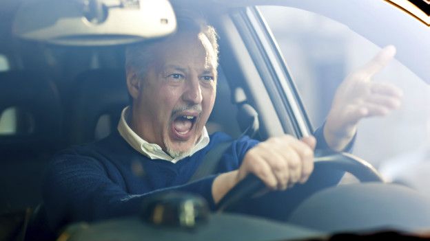Hombre enojado manejando un auto