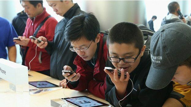 Jóvenes chinos revisan tabletas y celulares 