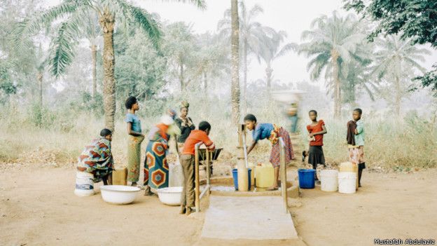 Mujeres y niños recogen agua de un pozo en Osukputu, Nigeria.