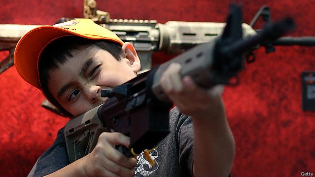 Un niño sostiene un arma durante la exposición anual de la Asociación Nacional del Rifle de EE.UU. (NRA).