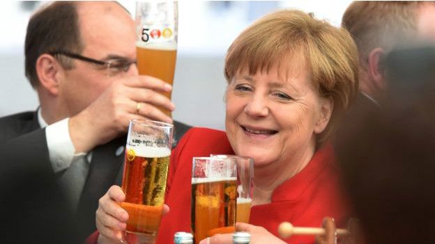 Ángela Merkel brindando con cerveza
