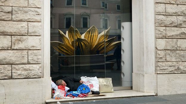 Mendigos durmiendo en las calles de Italia, como este frente a la Plaza San Silvestro, en Roma.