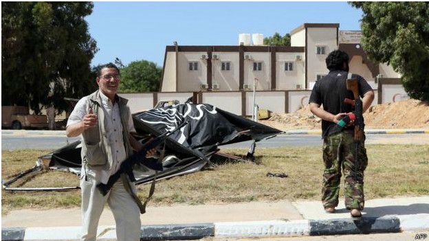 160611054409_a_man_cheers_in_front_of_a_wrecked_is_sign_in_sirte_624x351_afp.jpg