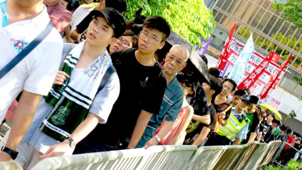 香港行政长官办公室外示威者鱼贯通过警察围栏（BBC中文网图片21/8/2016）