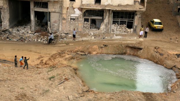 阿勒頗居民察看一處填滿水的受損地帶