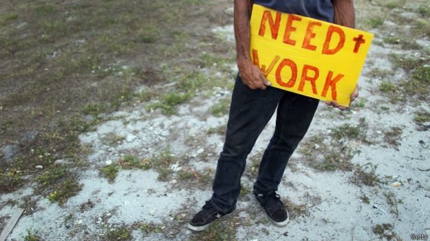 Una persona con un cartel de "se busca trabajo"