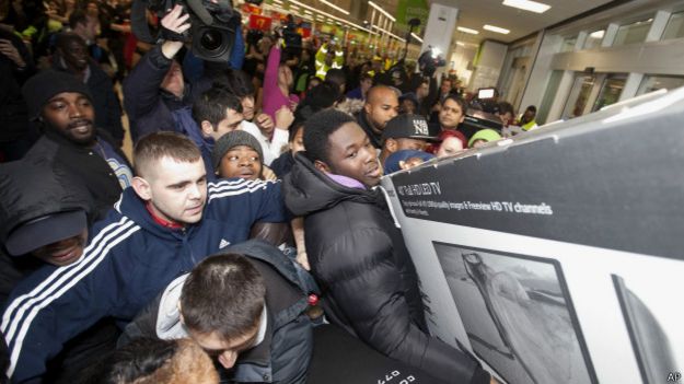 Compradores se esforçam para comprar eletrônicos em Londres (Foto: AP)