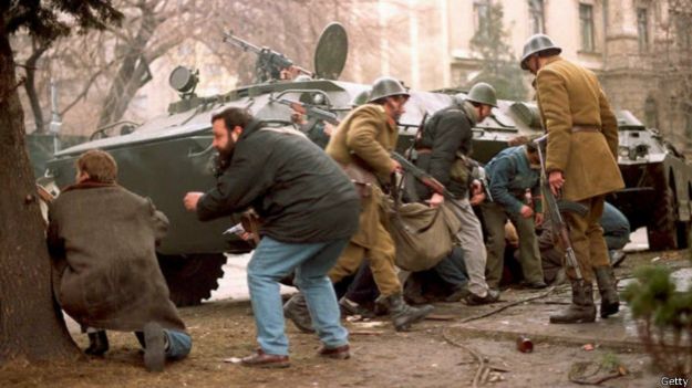 Румынские солдаты и жители Бухареста прячутся за танком от снайперов (24 декабря 1989 г.)