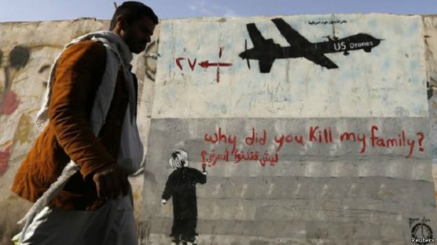 رجل يمر بجانب رسم يقول "ليش قتلت أسرتي؟"