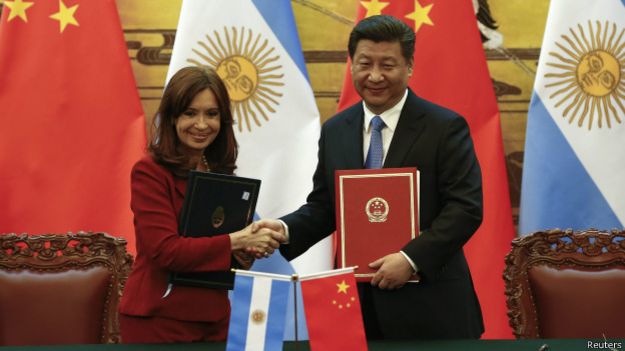 Los presidentes de Argentina y China se estrechan las manos.