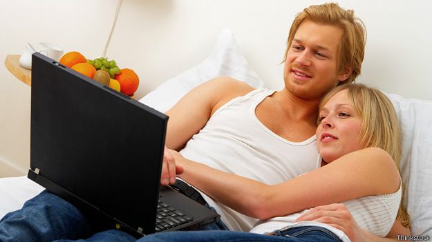 Молодая пара в постели с ноутбуком