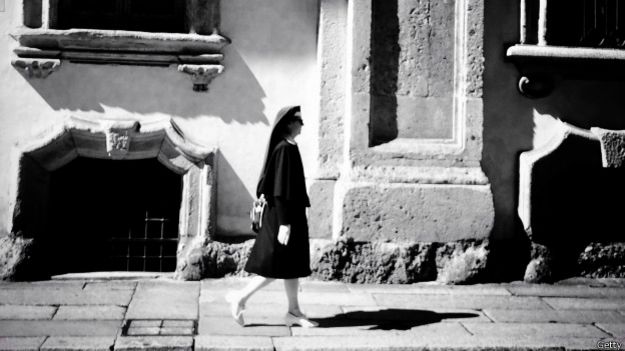Una religiosa camina por una calle desierta